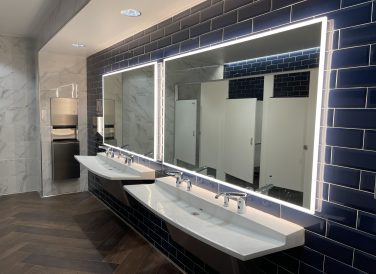 Bathroom sinks and mirrors with warm lights at Brownsville PUB New Annex Building